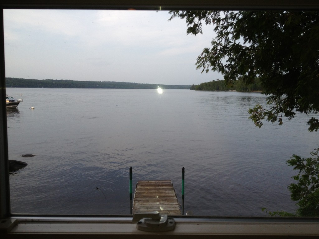 View of Sebec Lake through living loom window of cottage